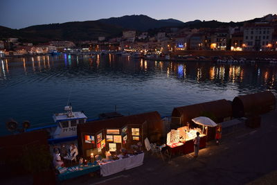 High angle view of illuminated buildings by sea at night