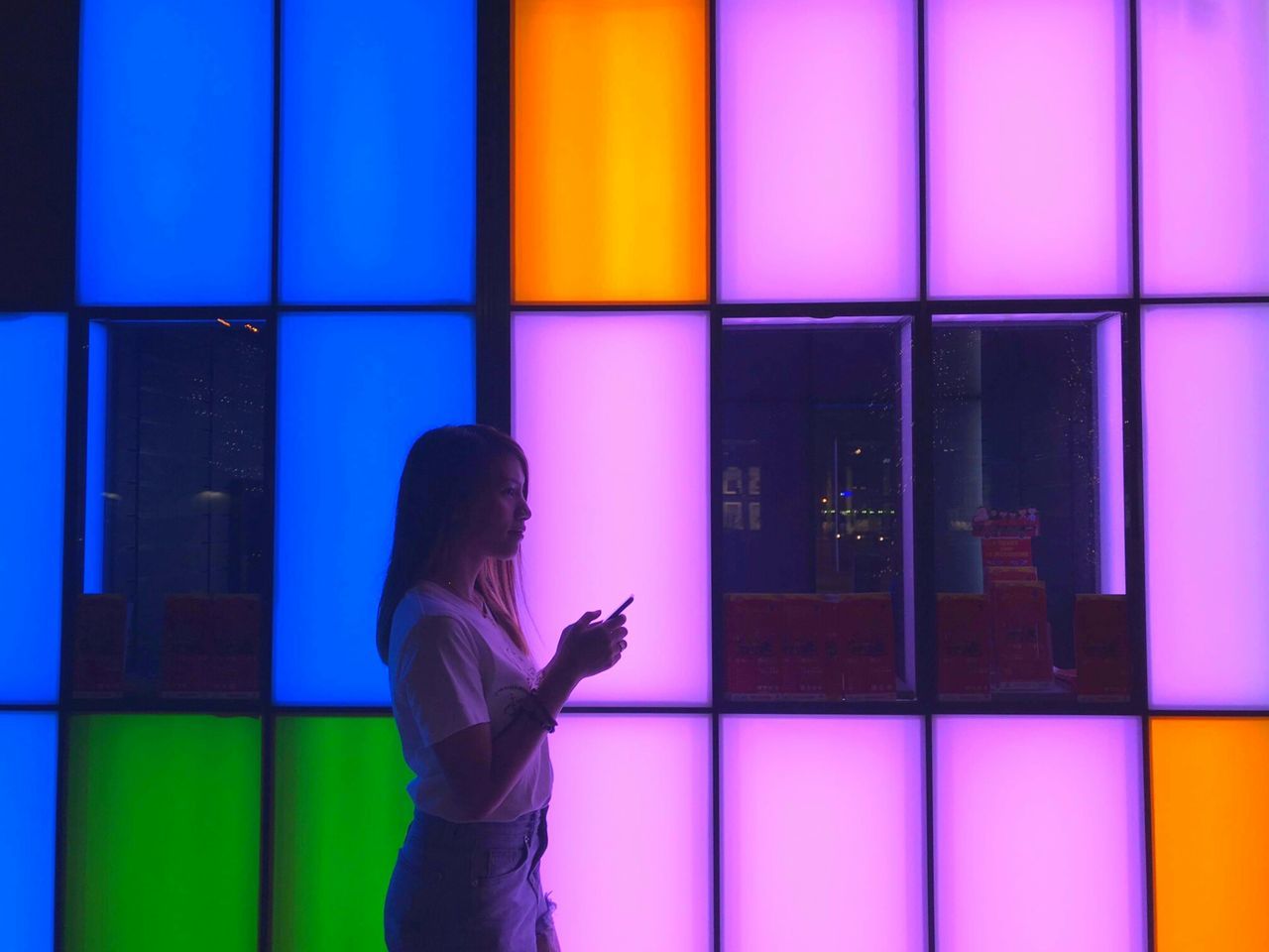 SIDE VIEW OF WOMAN USING MOBILE PHONE IN OFFICE