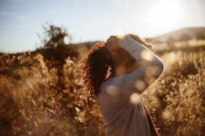 Woman tying hair against plants