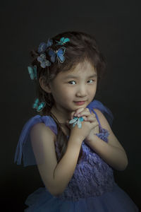 Close-up portrait of boy over black background