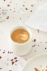 Cappuccino in a white mug on a terrazzo table