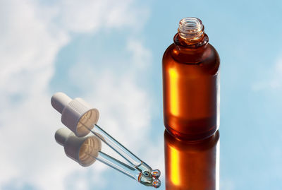 Close-up of glass bottle against blue background