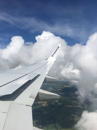 Close-up of airplane wing against cloudy sky