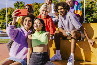 Portrait of smiling friends standing on street