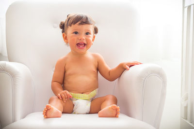 Portrait of smiling girl sitting in bedroom