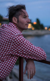 Side view of young man against sky