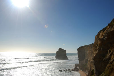 Scenic view of sea and cliff against clear sky