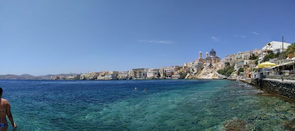 Panoramic view of sea and buildings against clear blue sky