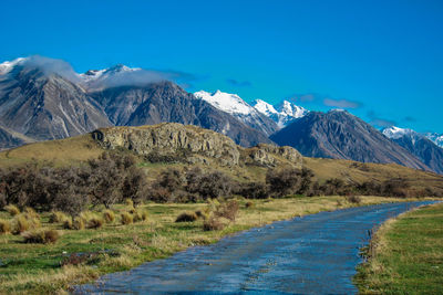 Scenic view of snowcapped mountains against blue sky