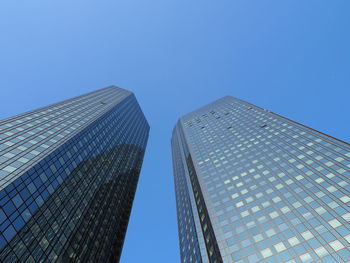 Low angle view of skyscrapers against clear blue sky