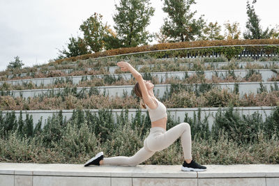 Full length of young woman exercising at park