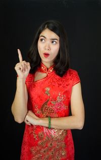 Portrait of beautiful young woman against black background