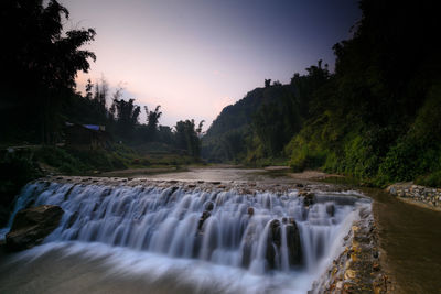 Scenic view of river stream against sky at sunset