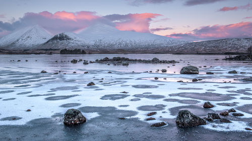 Sunrise over a frozen lochan na h-achlaise on rannoch moor near to glencoe in the scottish highlands