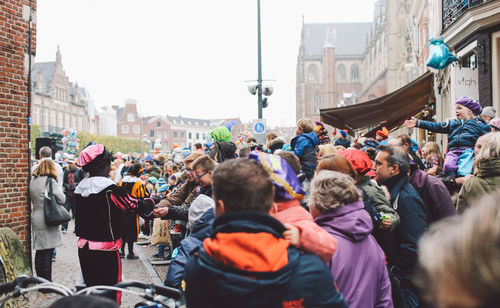 Crowd in city against sky