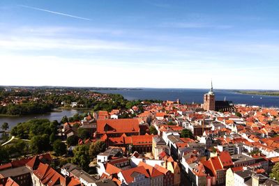 High angle view of townscape by sea against sky