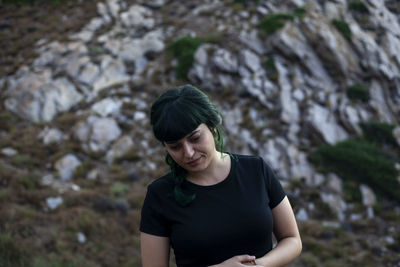 Portrait of a smiling young woman standing on rock