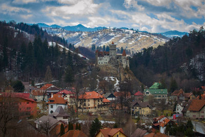 Aerial view of town by mountains against sky