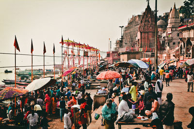 People at market stall against clear sky