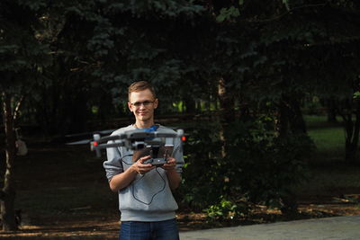  drone pilot. the young man holds the drone controller in his hands and controls the mavic drone. 