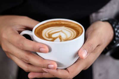 Midsection of woman holding coffee cup