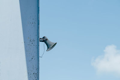 Old loudspeaker mounted on blue metal wall