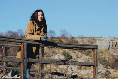 Portrait of woman sitting against clear sky