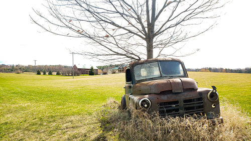 Abandoned truck on field against sky