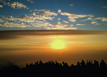 Silhouette people against sky during sunset