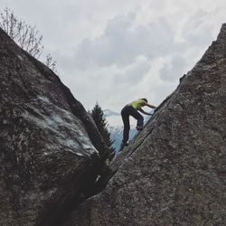 Full length of man standing on mountain against cloudy sky