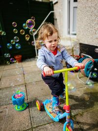 Cute girl playing with bubbles on scooter