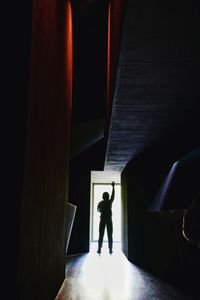 Rear view full length of silhouette man standing in corridor
