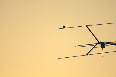 Low angle view of silhouette bird flying against clear sky