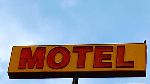 Low angle view of information sign against blue sky