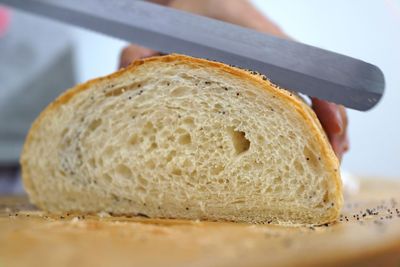 Cropped hand of person cutting bread