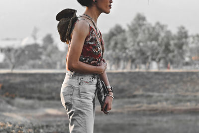 Side view of young woman standing outdoors