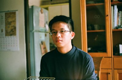 Portrait of young man standing against wall