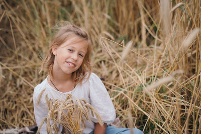 Portrait of young woman standing amidst plants