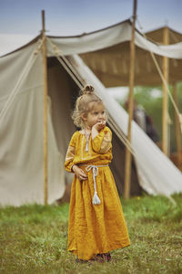 Portrait of young woman standing on field