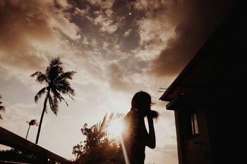 Silhouette woman standing against sky during sunset