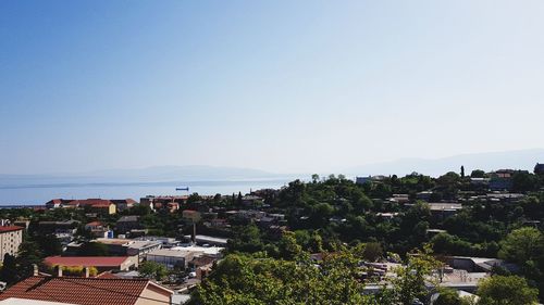 High angle view of townscape by sea against clear sky