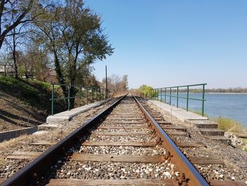 Railroad tracks amidst trees against clear sky