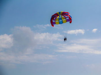 Low angle view of person paragliding against sky