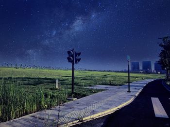 Road signal at roadside by field