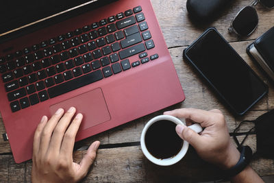 Midsection of man using laptop on table