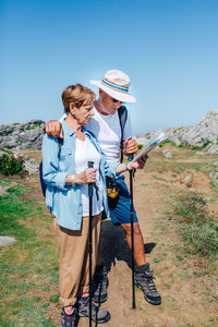 Senior couple hiking looking at map in rocky landscape