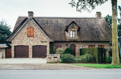 Old building by road against clear sky