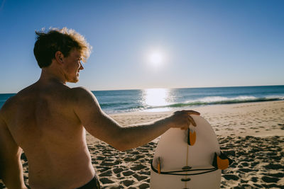 Man standing on beach against clear sky