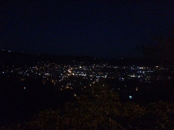 Illuminated cityscape against sky at night