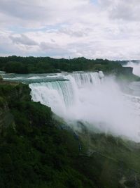 Scenic view of waterfall against sky